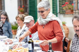 Woman serving pasta at family lunch in garden, Florence, Italy Woman serving pasta at family lunch in garden, Florence, Italy